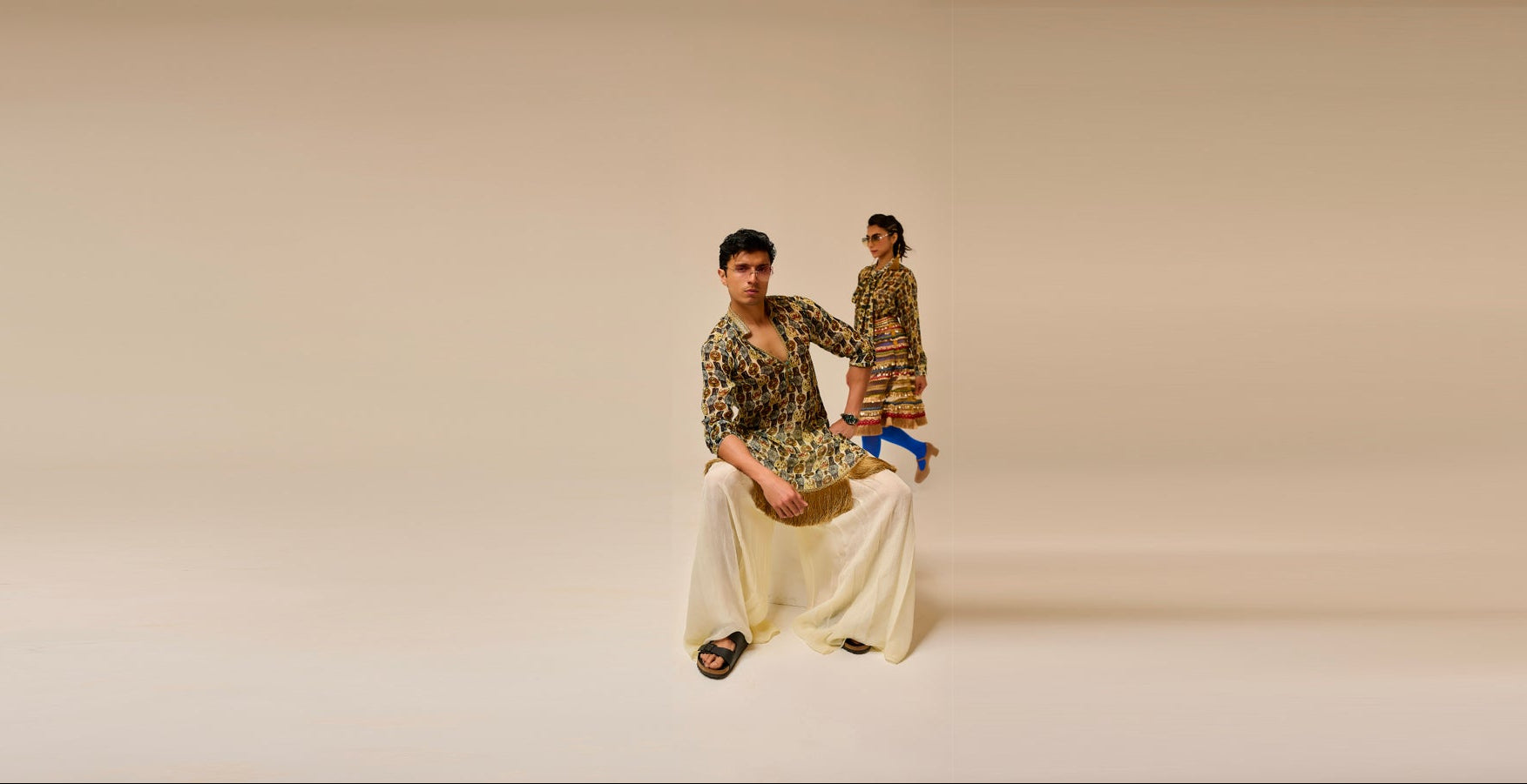 Two people in formal attire standing on a beige background