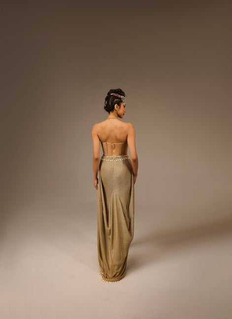 Woman wearing a long, elegant dress with a high slit on a plain background