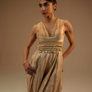 Woman wearing a gold evening gown against a beige background