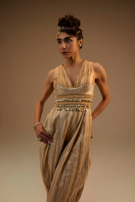 Woman wearing a gold evening gown against a beige background