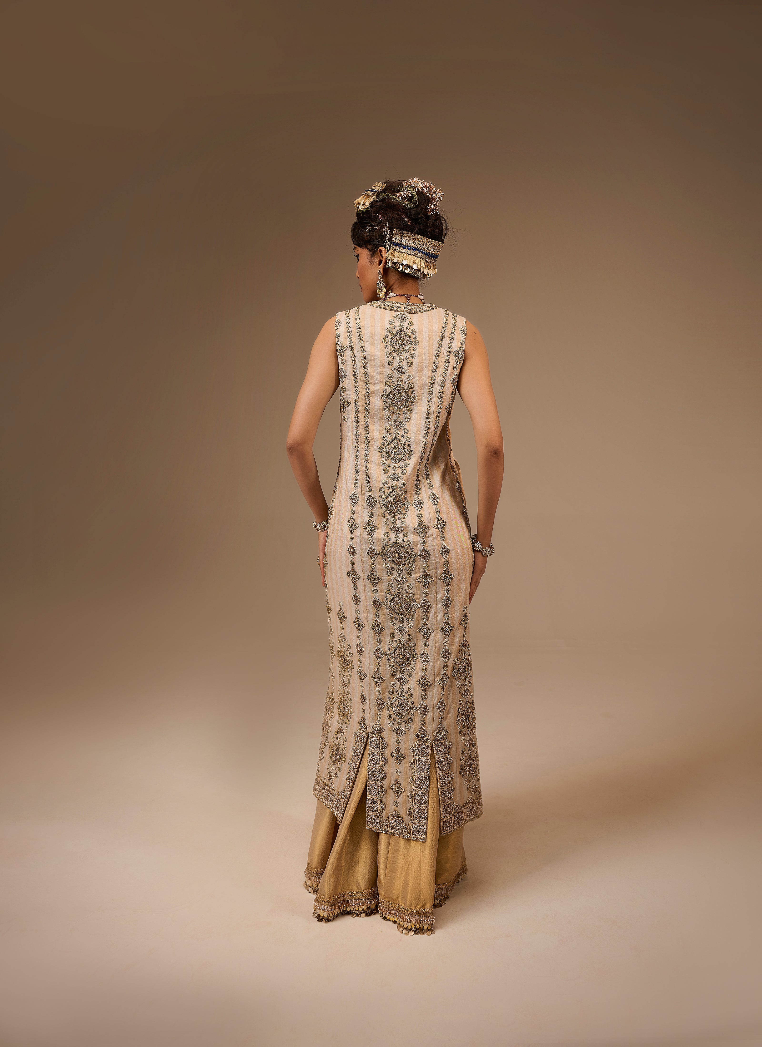 Woman wearing a traditional embroidered dress with a plain background