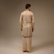 Person wearing a traditional outfit with a plain background