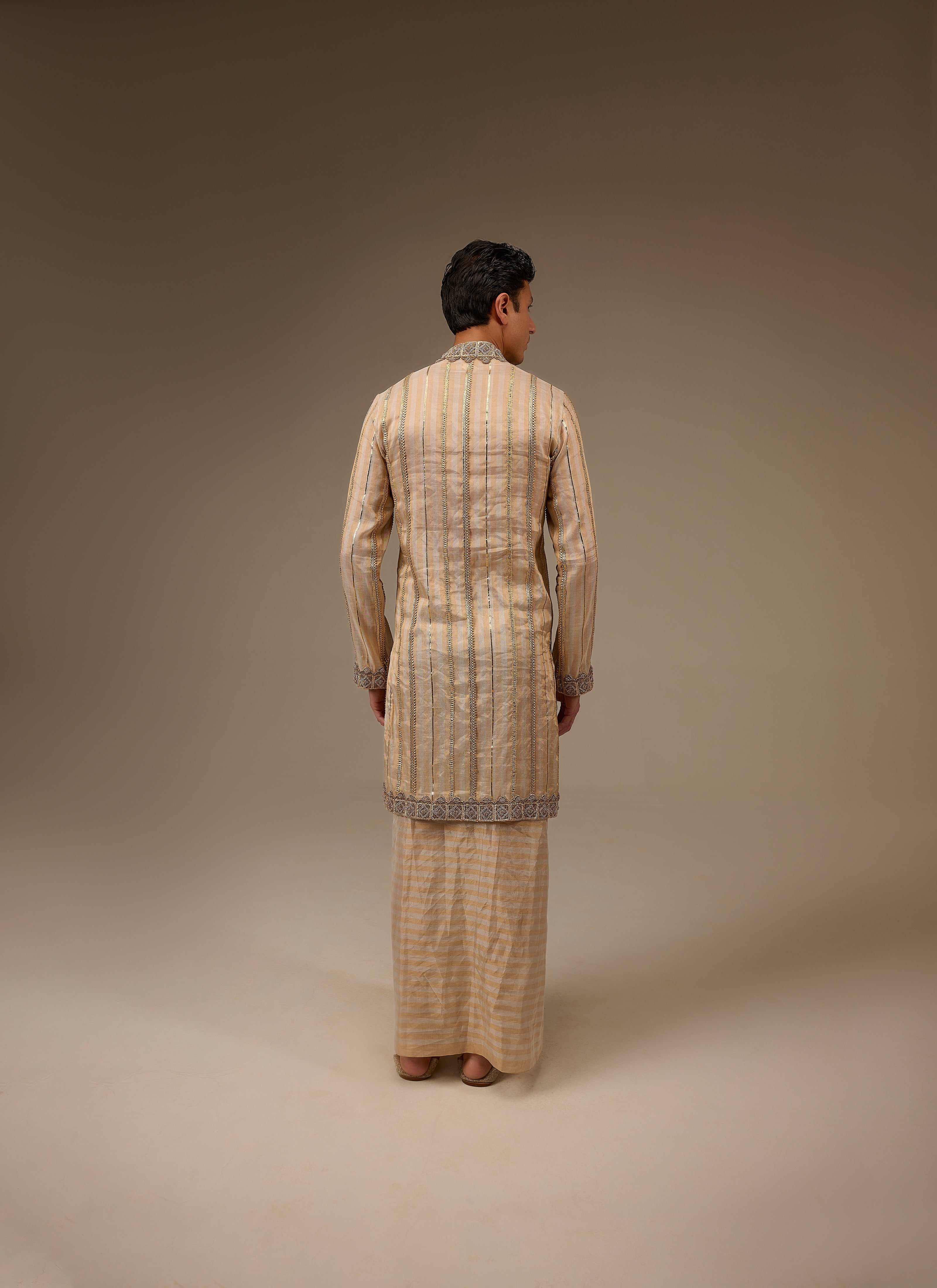 Person wearing a traditional outfit with a plain background