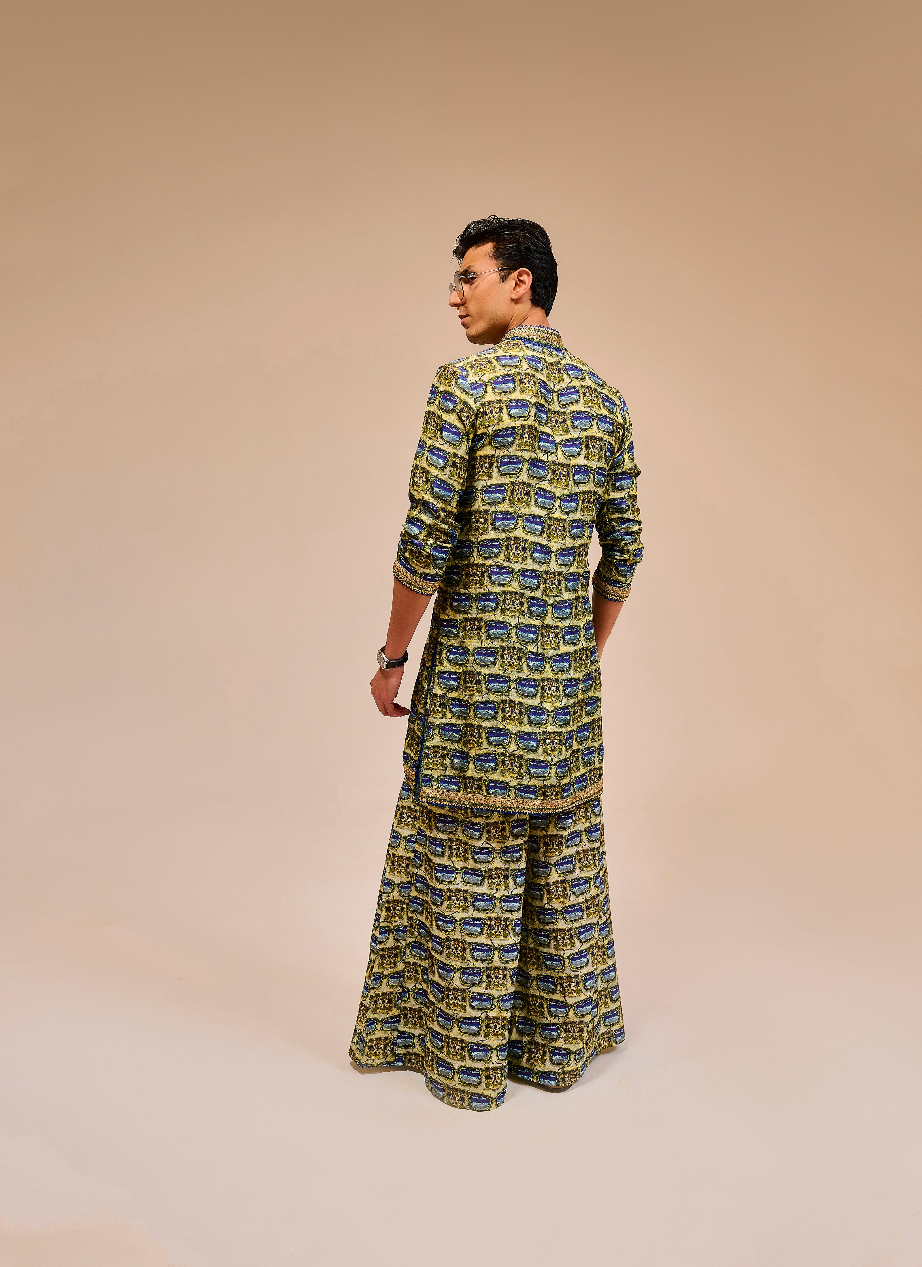 Man wearing a patterned outfit on a beige background