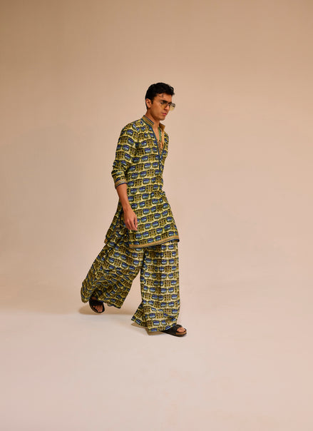 Man wearing a green and blue patterned outfit on a beige background