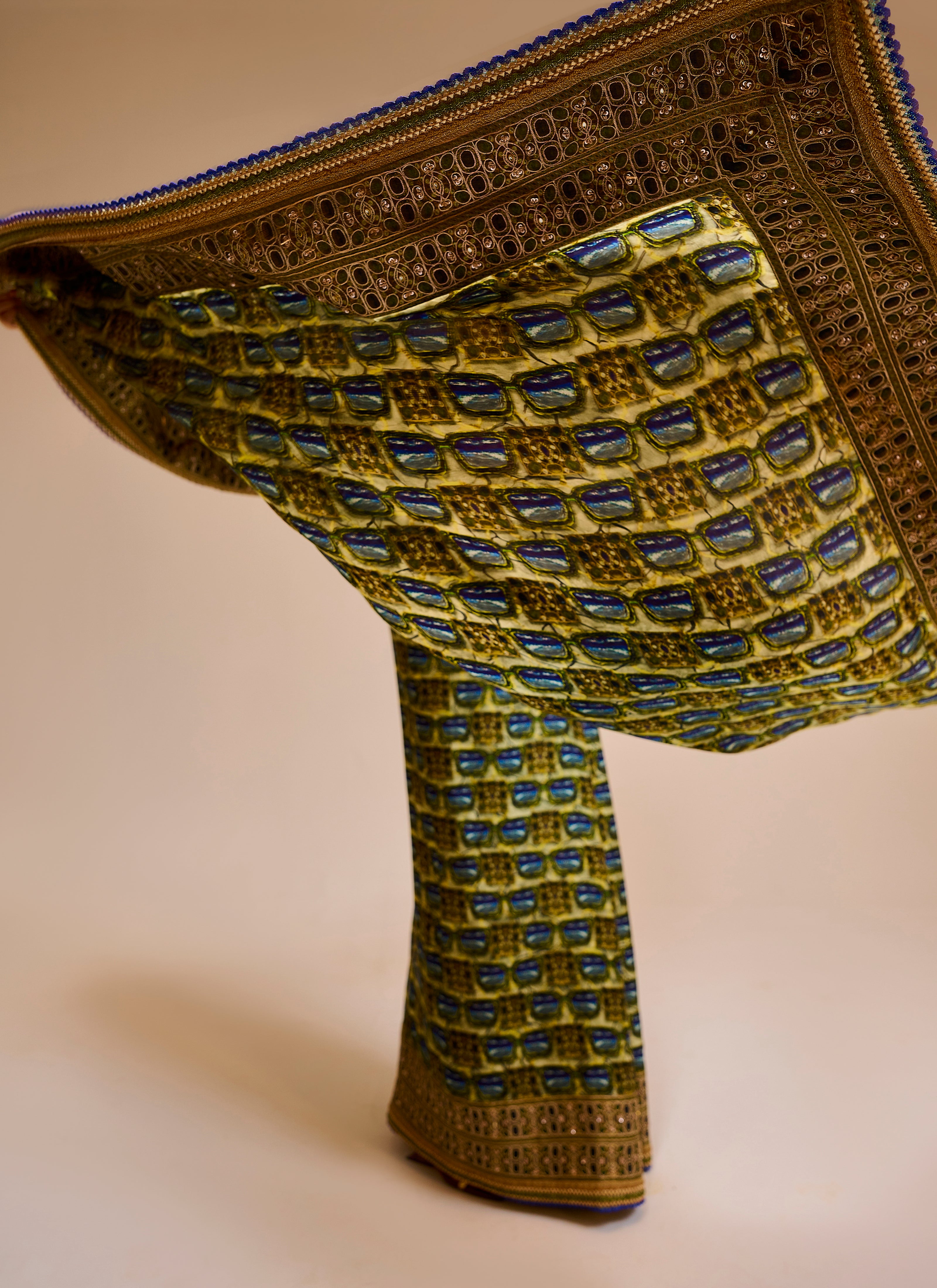 Decorative fabric with intricate patterns and embroidery on a beige background