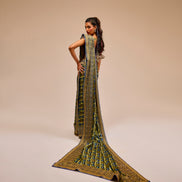 Woman wearing a long, intricately designed dress on a beige background