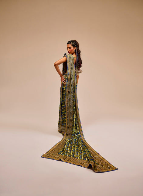 Woman wearing a long, intricately designed dress on a beige background