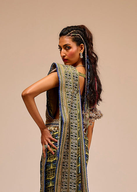 Woman wearing a long, intricately designed dress with a beige background