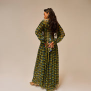 Woman wearing a green patterned dress against a beige background