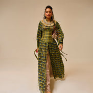 Woman wearing a long, patterned dress against a plain background