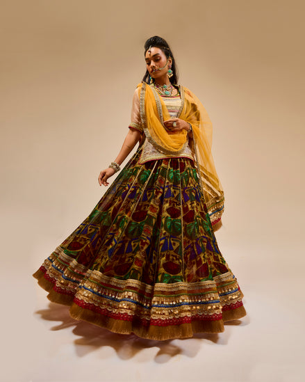Woman wearing a traditional outfit with a yellow dupatta on a beige background