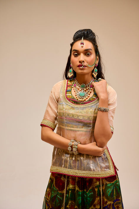 Woman in traditional attire with jewelry against a beige background