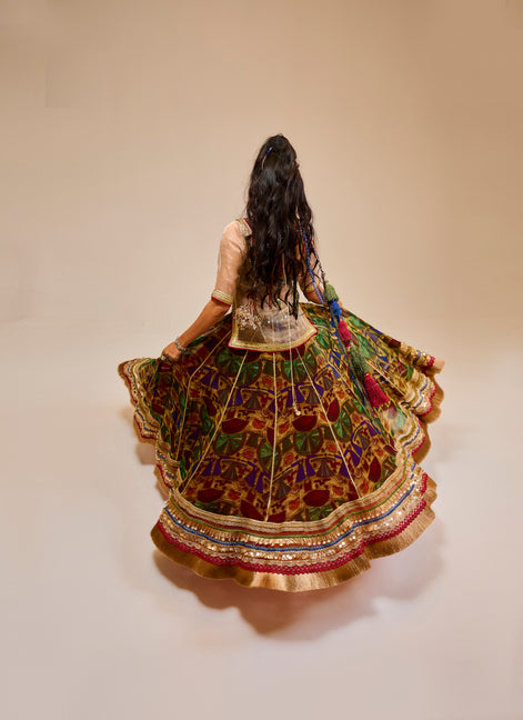 Woman in a colorful traditional outfit with a patterned skirt on a beige background