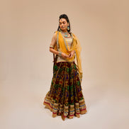 Woman in traditional attire with a yellow dupatta on a beige background