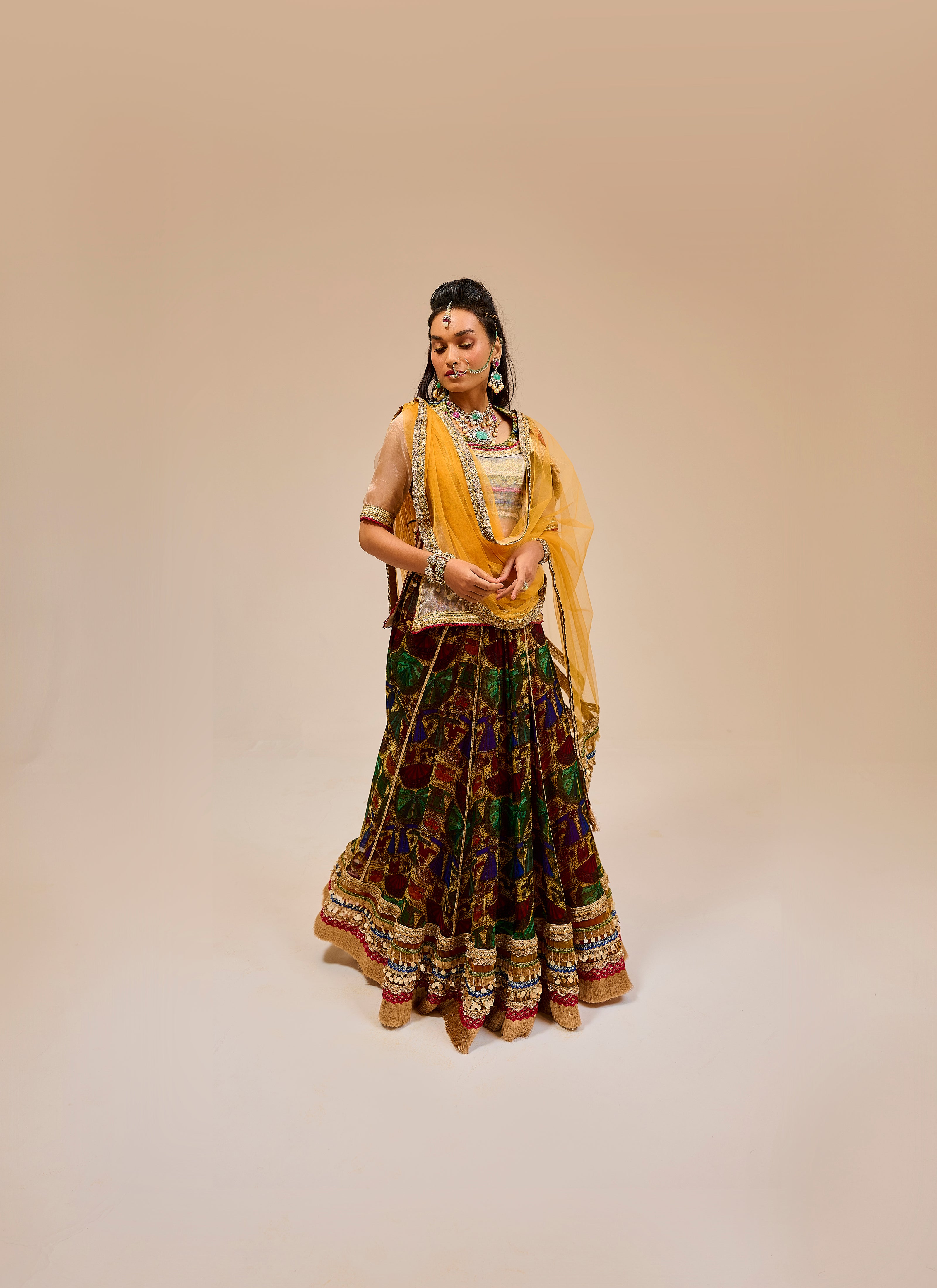 Woman in traditional attire with a yellow dupatta on a beige background