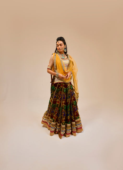 Woman in traditional attire with a yellow dupatta on a beige background