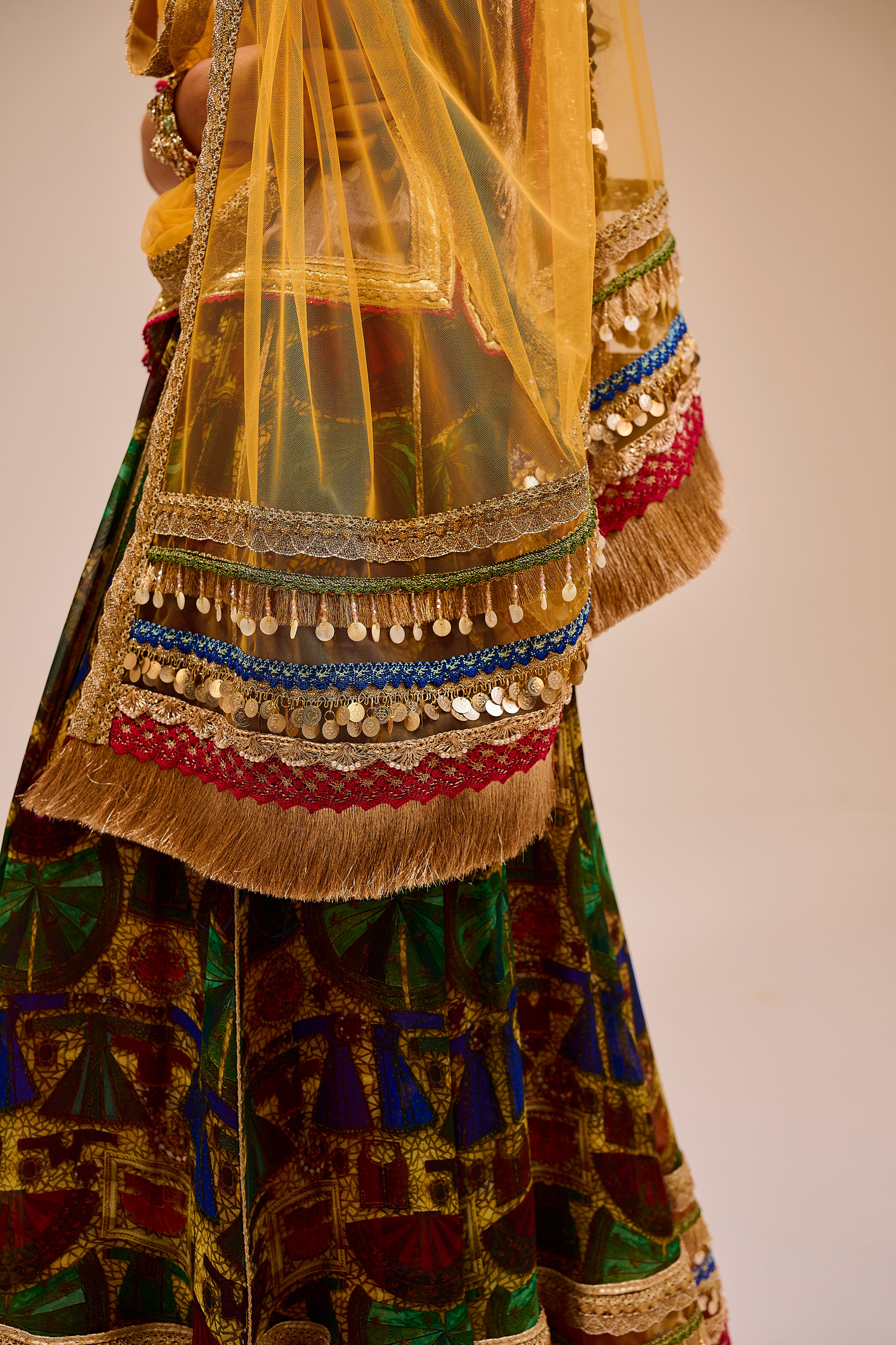 Colorful traditional outfit with intricate patterns and a sheer overlay.