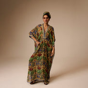 Woman wearing a colorful patterned dress and headscarf on a beige background