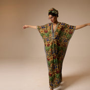 Woman wearing a colorful patterned dress and headscarf on a beige background