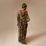 Woman wearing a colorful patterned dress against a beige background