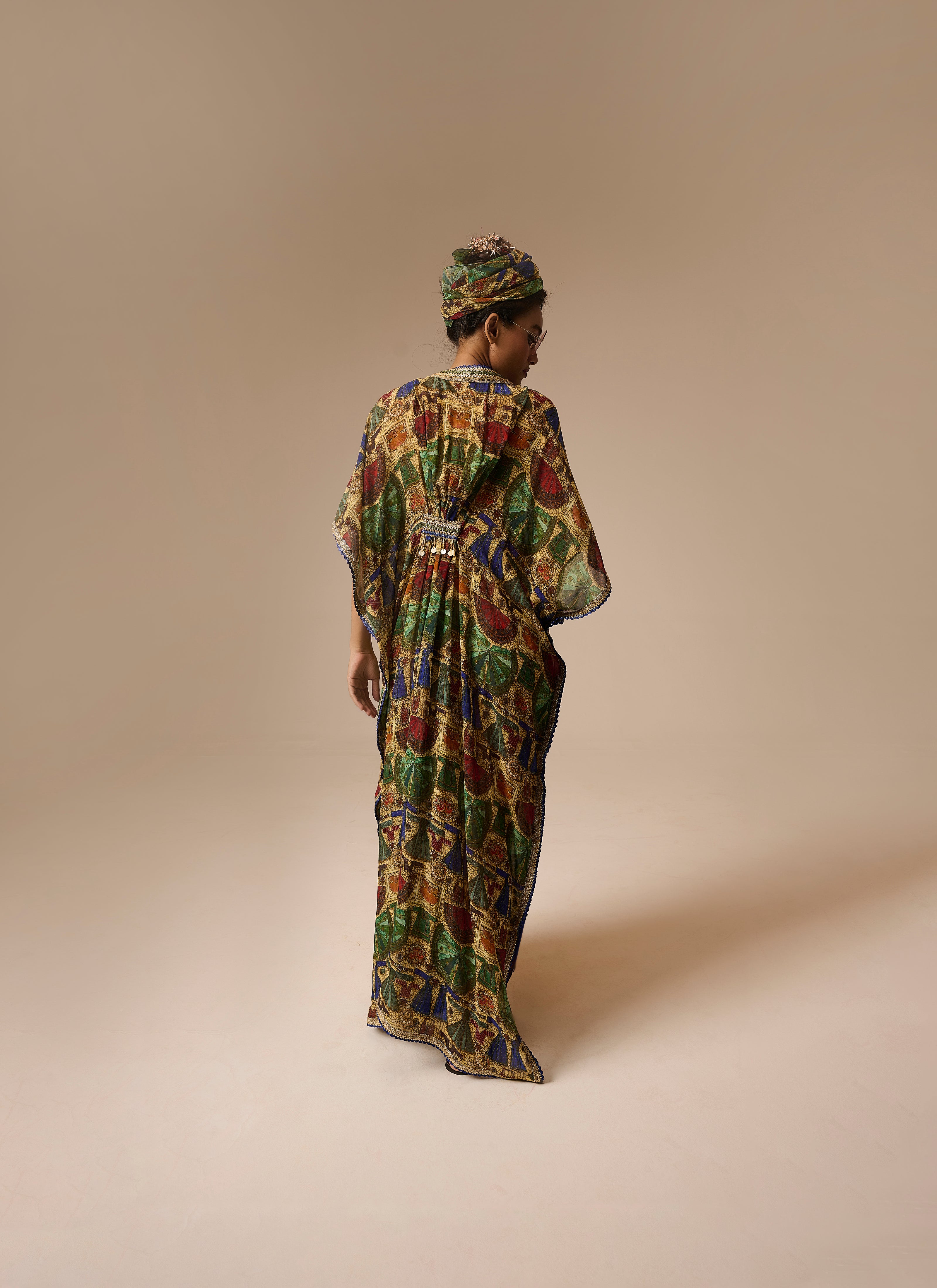 Woman wearing a colorful patterned dress against a beige background