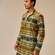 Man wearing a patterned kurta against a beige background