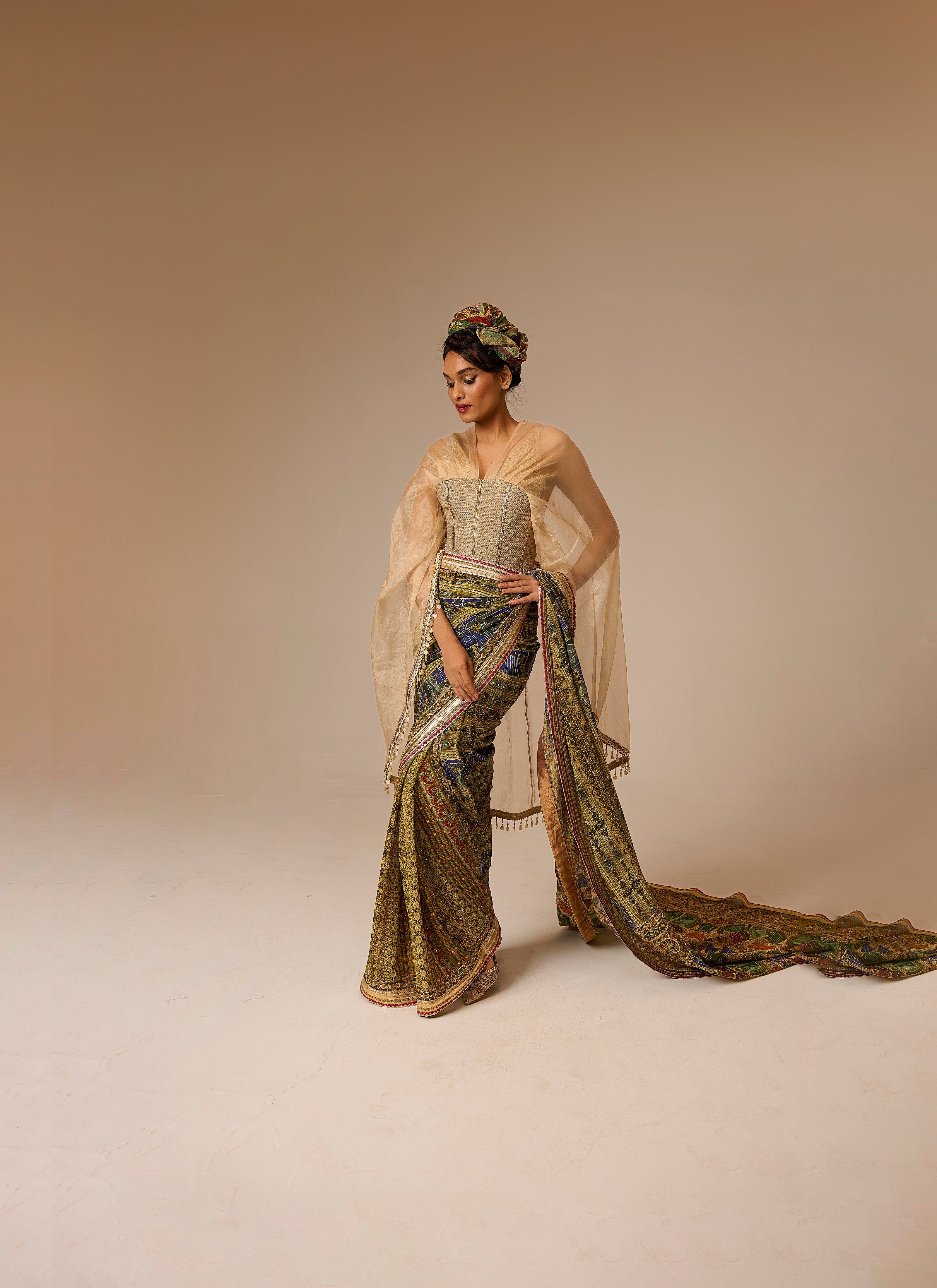 Woman in a traditional outfit with a long, flowing garment on a beige background