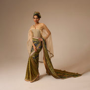 Woman in a traditional outfit with a long, flowing garment on a plain background
