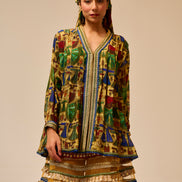 Woman wearing a colorful traditional outfit with a patterned jacket and skirt on a beige background