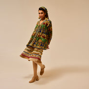 Woman wearing a colorful traditional outfit on a beige background