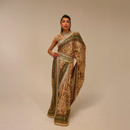 Woman wearing a traditional embroidered saree on a beige background