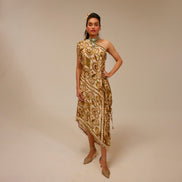 Woman wearing a gold and beige patterned dress against a beige background