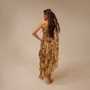 Woman in a patterned dress standing against a beige background