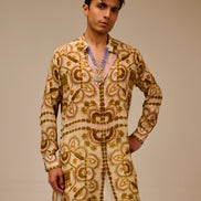 Man wearing a traditional embroidered kurta with a beige background