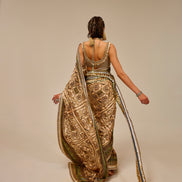 Woman wearing a long, patterned dress with a plain background