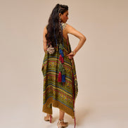 Woman wearing a colorful patterned dress with fringe on a beige background