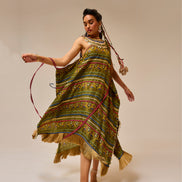 Woman wearing a colorful patterned dress with a plain background