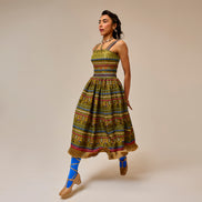 Woman wearing a colorful patterned dress on a beige background