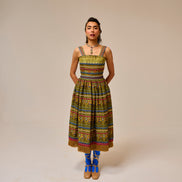 Woman wearing a colorful patterned dress on a beige background
