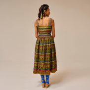 Woman wearing a colorful patterned dress on a beige background