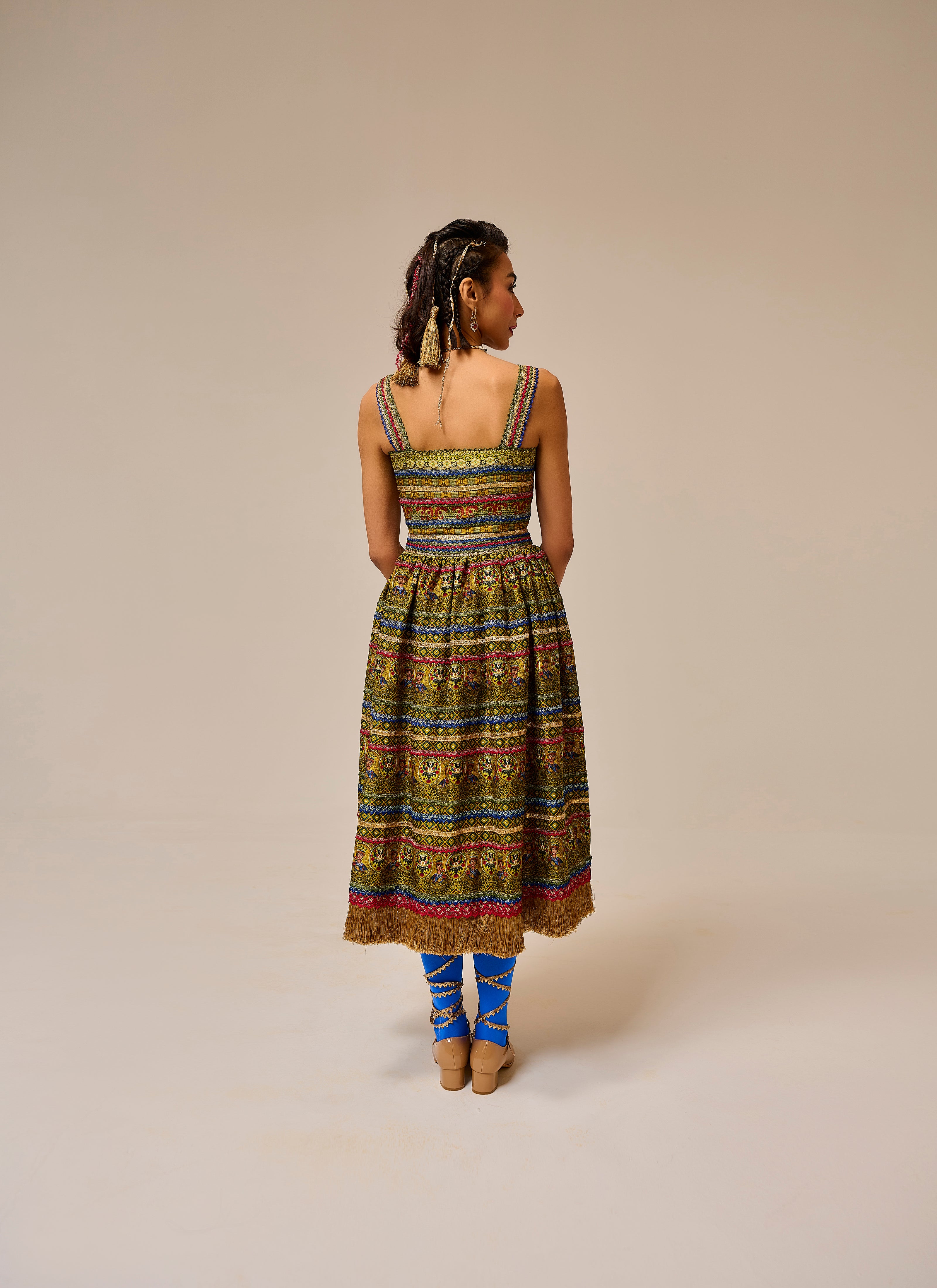 Woman wearing a colorful patterned dress on a beige background