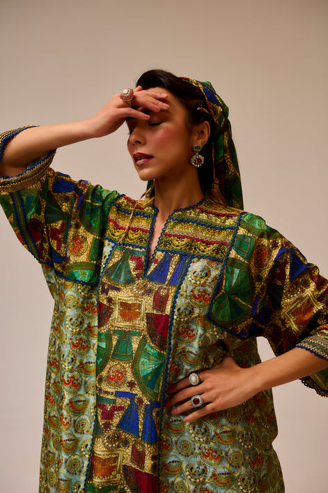 Woman wearing a colorful patterned dress against a plain background
