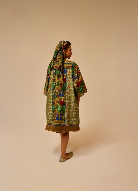 Woman wearing a colorful patterned dress and headscarf on a beige background