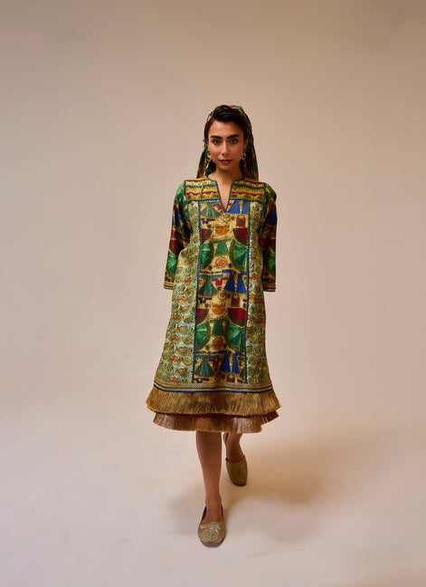 Woman wearing a colorful patterned dress on a plain background