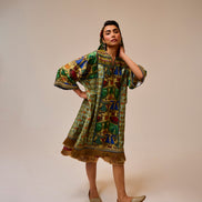 Woman wearing a colorful patterned dress on a beige background