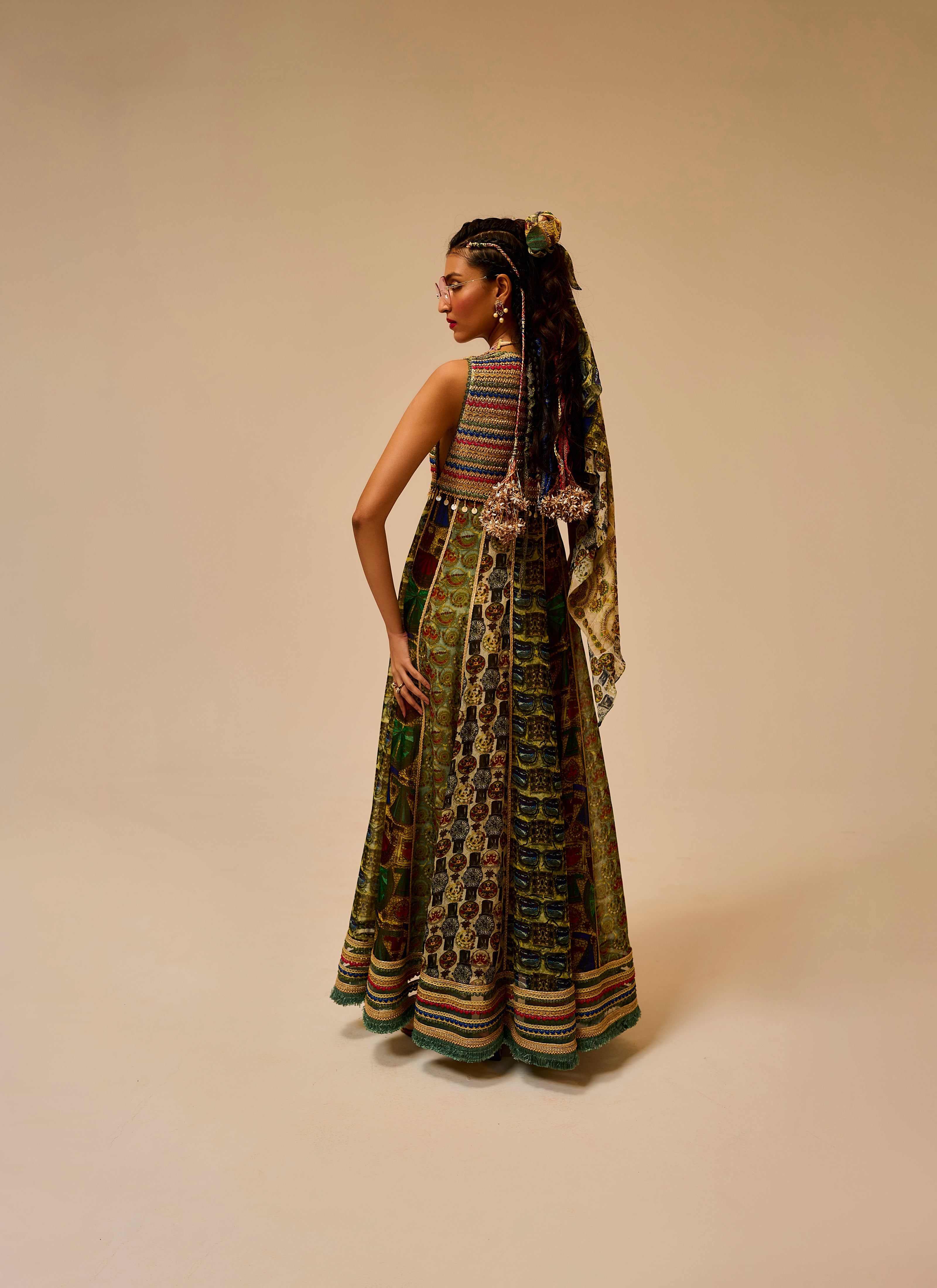 Woman wearing a long, patterned dress with a beige background