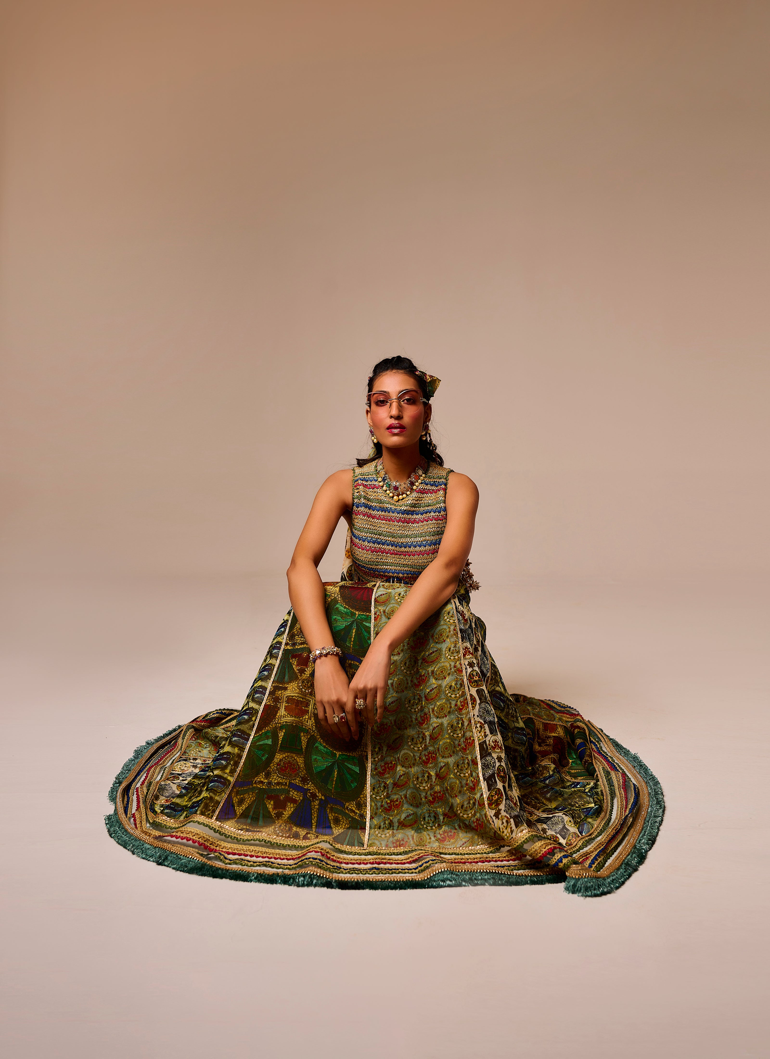 Woman in a colorful traditional outfit sitting on a beige background