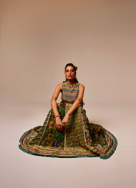 Woman in a colorful traditional outfit sitting on a beige background