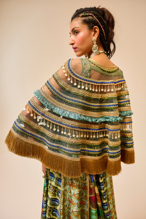 Woman wearing a colorful, patterned shawl with fringe details on a beige background